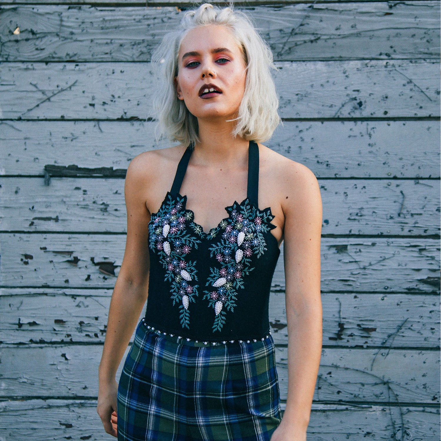 model in Vintage black wool bustier with floral beaded embellishments, halter neckline, and sculpted silhouette.