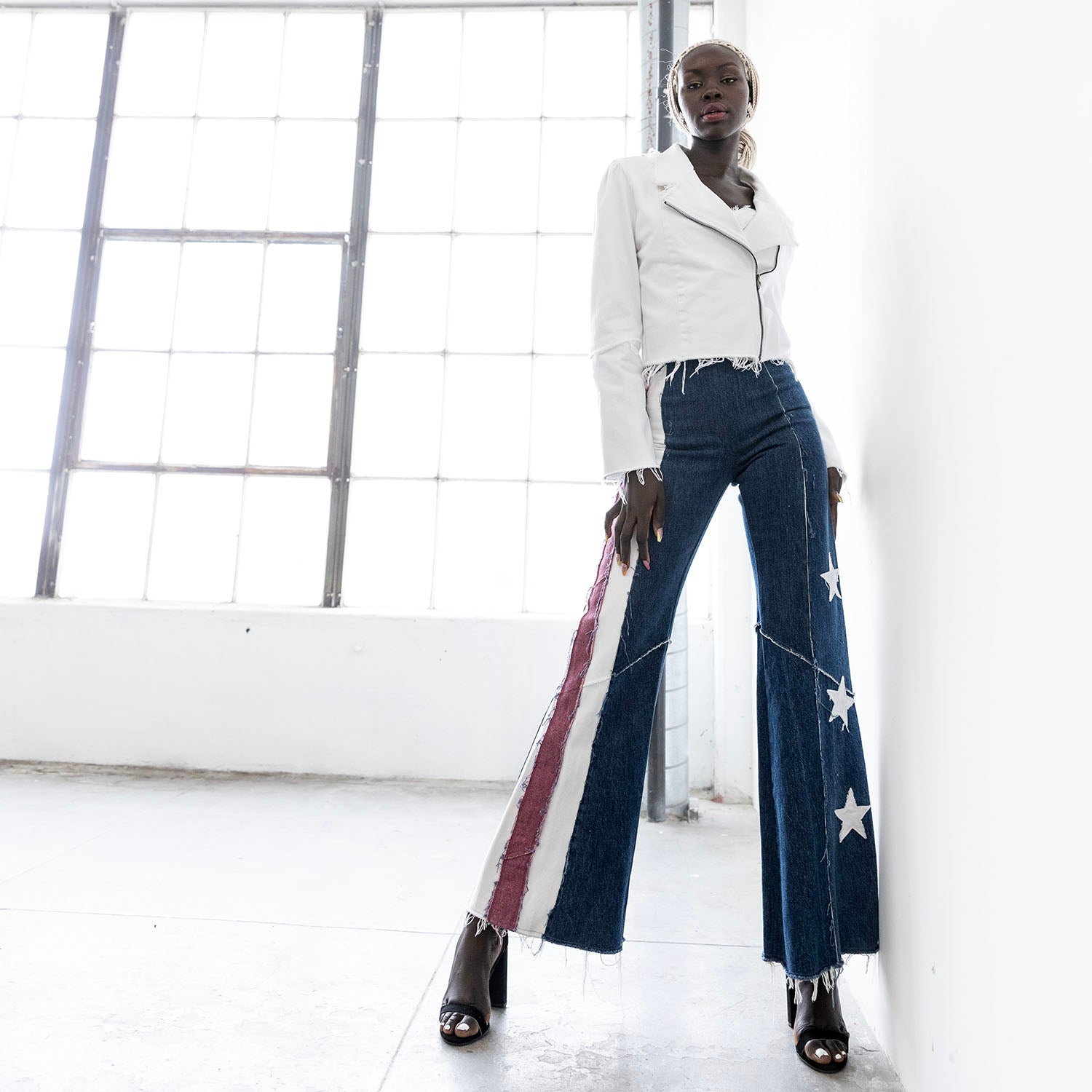 High-waisted flared denim jeans with appliqué stars and stripes, crafted from upcycled denim