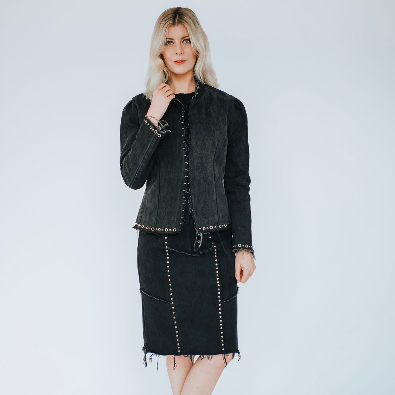 model in Blair Dress – fitted studded black denim dress with raw-edge hem, antique brass studs, and exposed metal zipper, worn with matching Galena Jacket.
