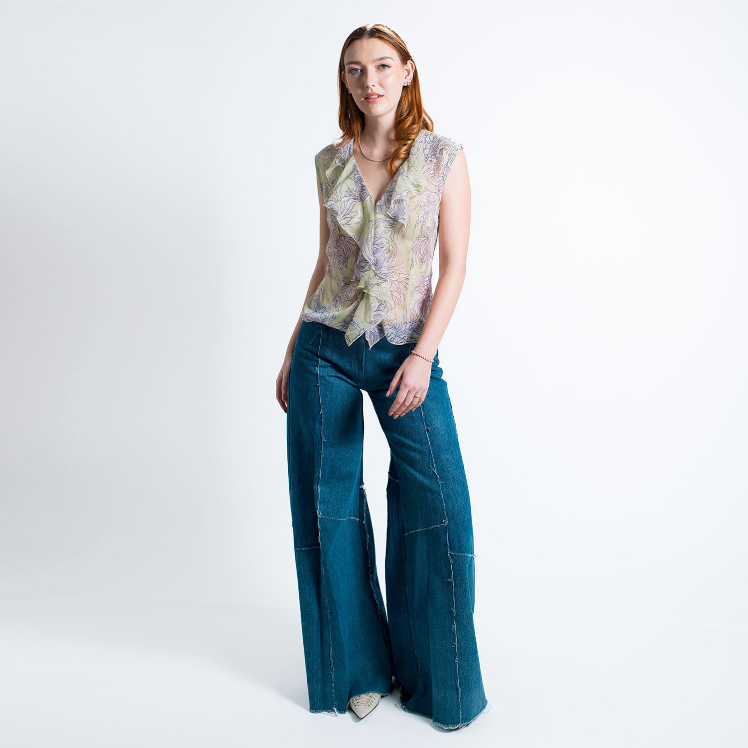 model in Alex Jean in Medium Blue – wide-leg low-rise upcycled denim jeans with fly front and raw hem, shown in soft indigo wash.
