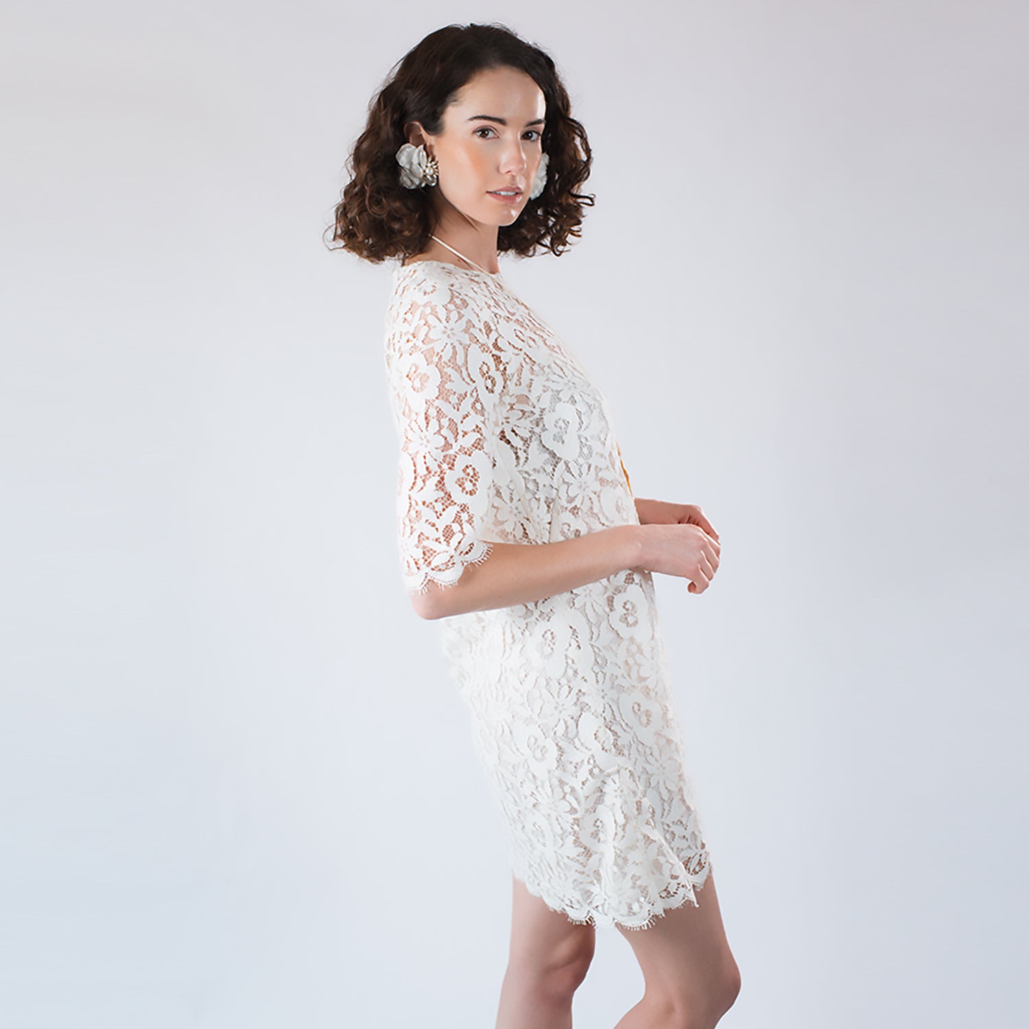 Model wearing oversized ivory flower statement clip-on earrings with crystal detailing.