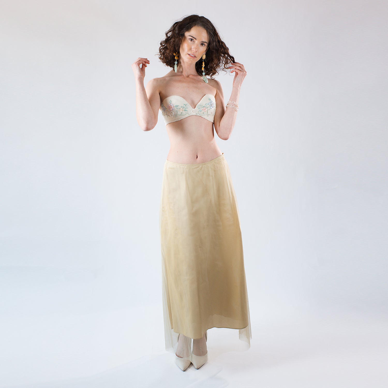 Model wearing the Aurelia silk taffeta midi skirt styled with a beaded strapless bustier