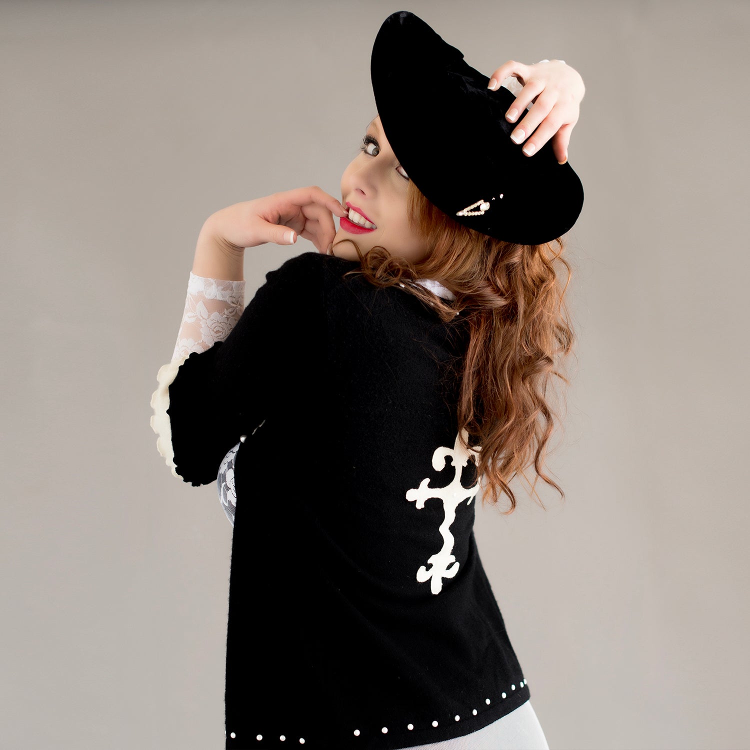 model Black cashmere ruffle-sleeved cardigan with cross appliqué and pearl embellishments.