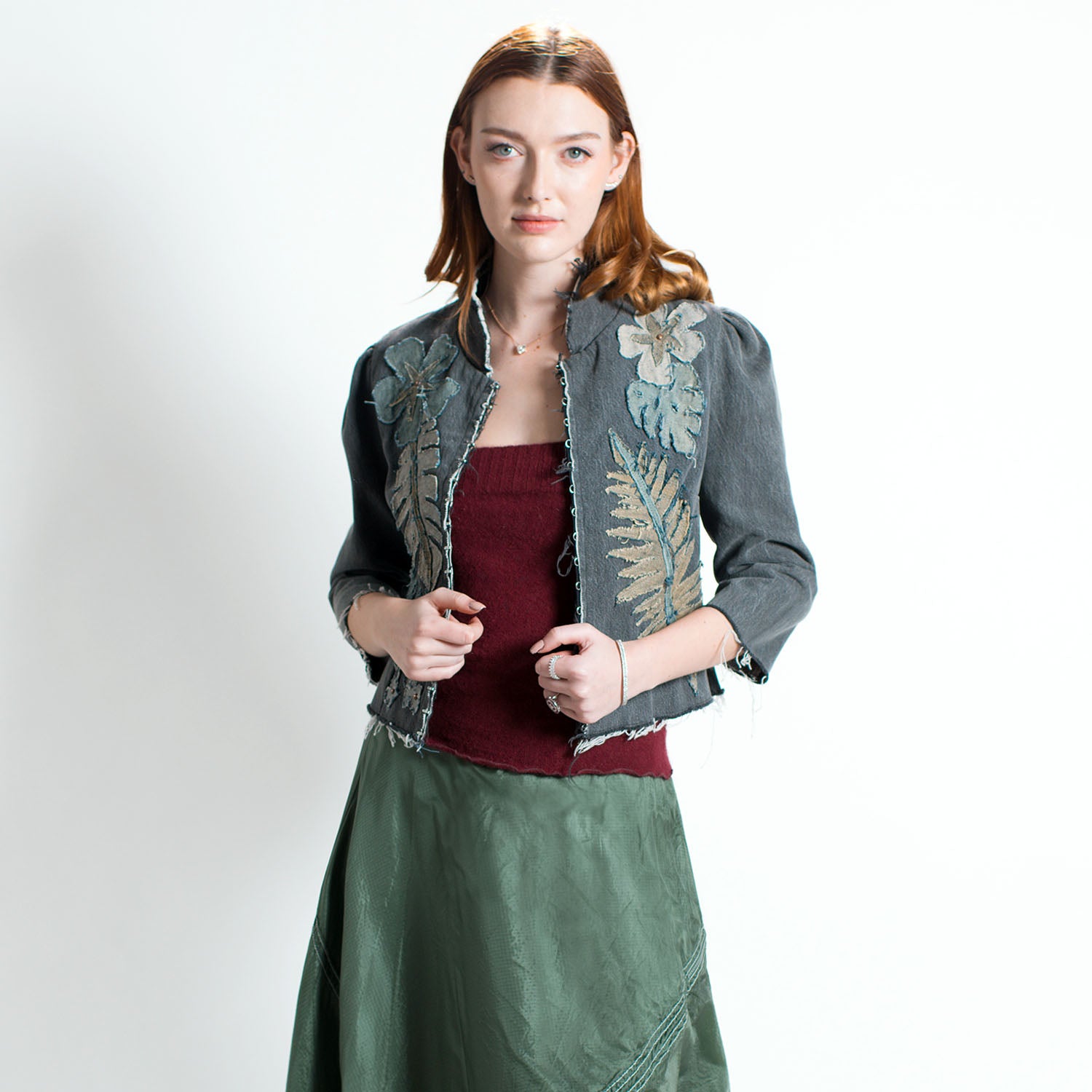 model in Audrey Jacket – cropped upcycled denim jacket with tropical floral appliqué, mandarin collar, and hook-front closure in fitted silhouette.