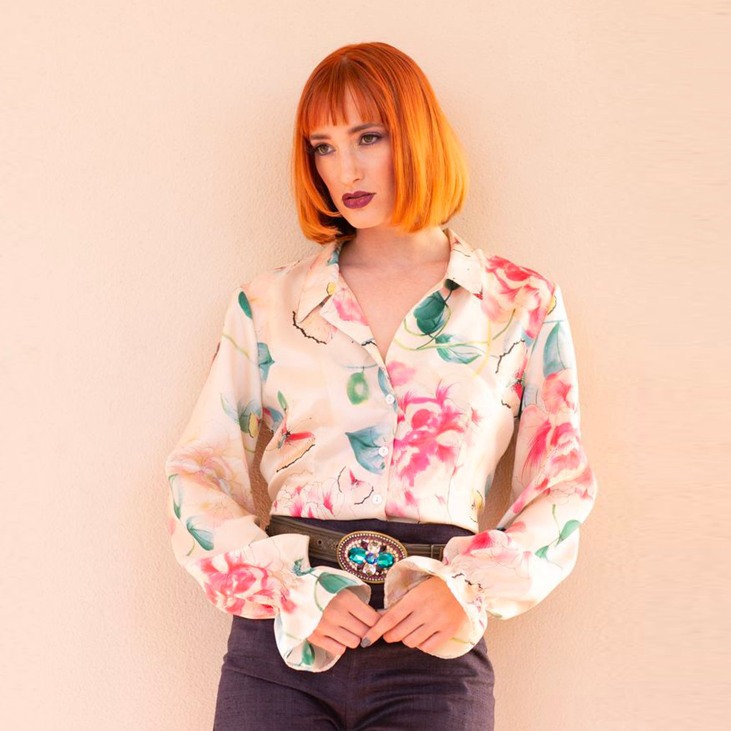 Silk floral blouse with tailored notched collar, puffed long sleeves, and ruffled elastic cuffs in soft pastel tones.