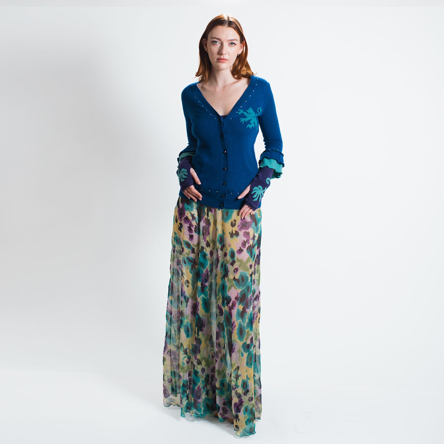 model in Griffin Cardigan in royal blue upcycled cashmere with griffin appliqué and ruffled chiffon sleeves, front view