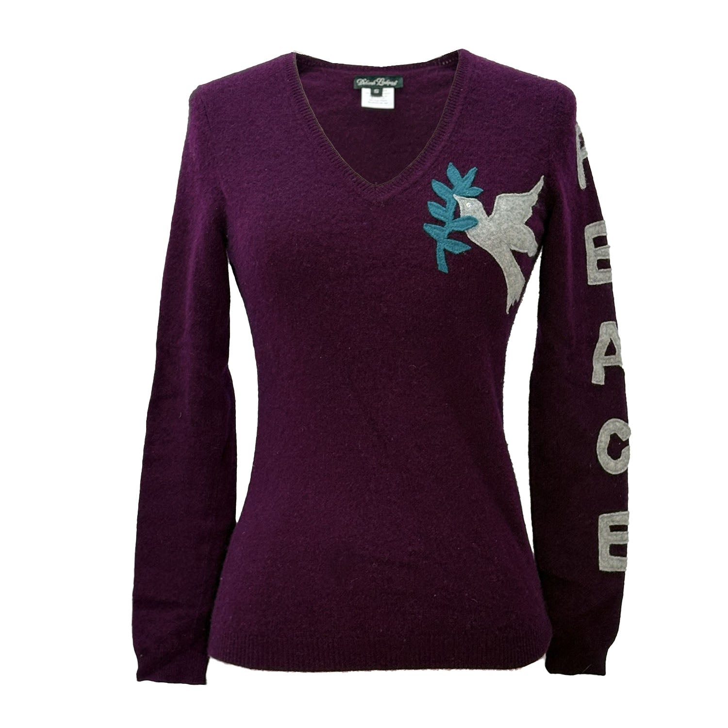 Deep purple cashmere pullover with appliquéd peace dove on chest and “PEACE” lettering down the sleeve.