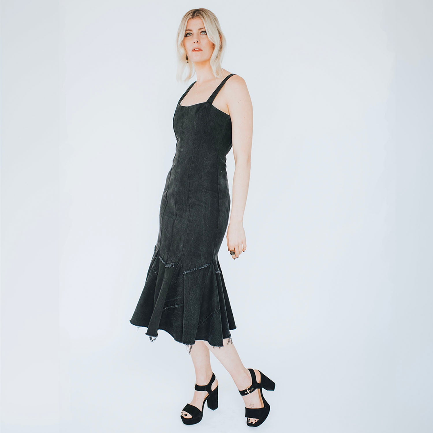 model in Twyla Dress – fit-and-flare upcycled denim dress with raw hem and exposed back zipper, mermaid silhouette shown in black.