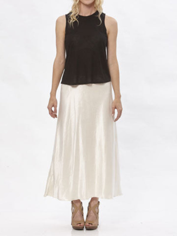 Model wearing the Katherine hemp/silk satin bias-cut skirt in cream, paired with a black sleeveless top.