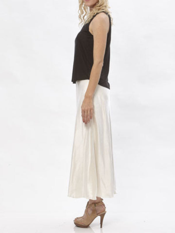 Model wearing the Katherine hemp/silk satin bias-cut skirt in cream, paired with a black sleeveless top.