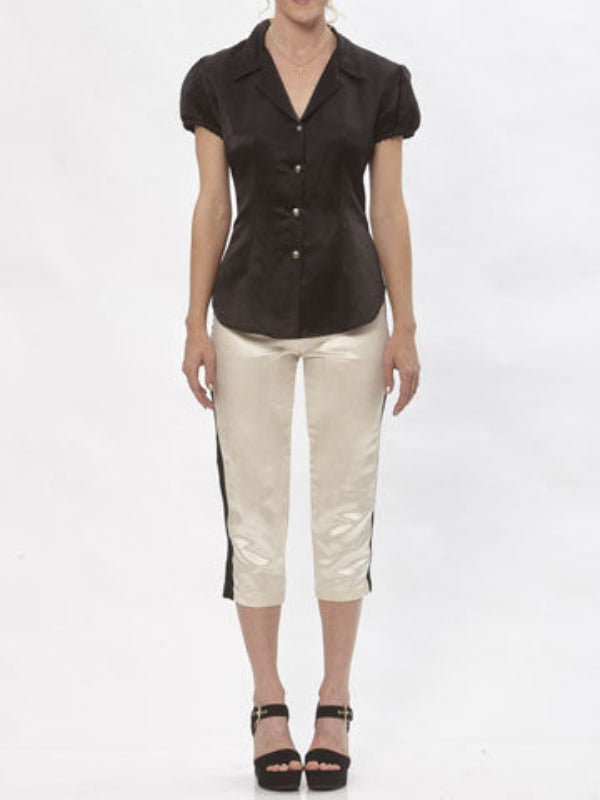 Model wearing cream hemp silk cigarette pants with black contrast side stripe and cropped hem, paired with black short-sleeve blouse.