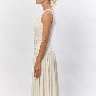 Model wearing the River Cowl Top by Deborah Lindquist, a sleeveless ivory modal knit top with a softly draped cowl neckline paired with a flowing asymmetrical skirt. Sustainably made in Los Angeles.