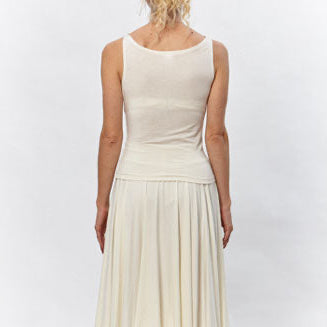 Model wearing the River Cowl Top by Deborah Lindquist, a sleeveless ivory modal knit top with a softly draped cowl neckline paired with a flowing asymmetrical skirt. Sustainably made in Los Angeles.