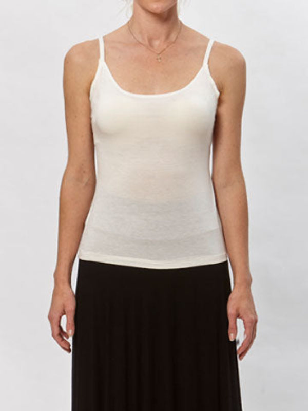 Minimalist white spaghetti strap tank top made from modal/spandex, shown with flared skirt.