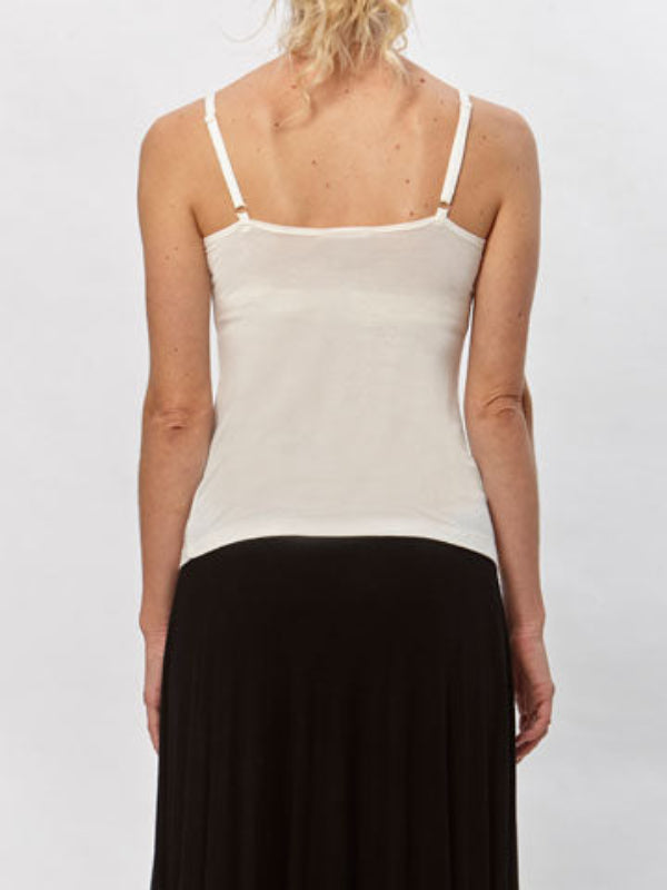 Minimalist white spaghetti strap tank top made from modal/spandex, shown with flared skirt.