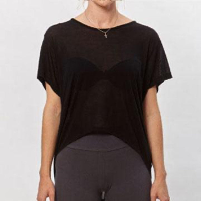 Model wearing the black Alina T-Shirt, a short-sleeved modal top with a high-low hem, paired with dark leggings.