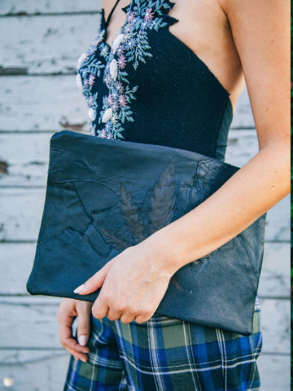 model with Limited edition eco-conscious leather clutch bag with hemp appliqué.
