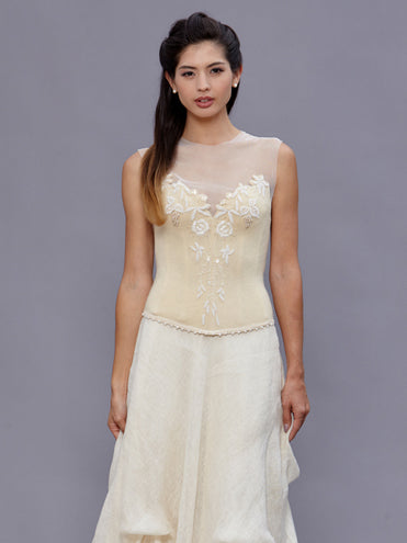 Model wearing the Janice Bustier, a vintage beaded wool bustier with pearl detailing and halter tie, paired with a linen bustle skirt.