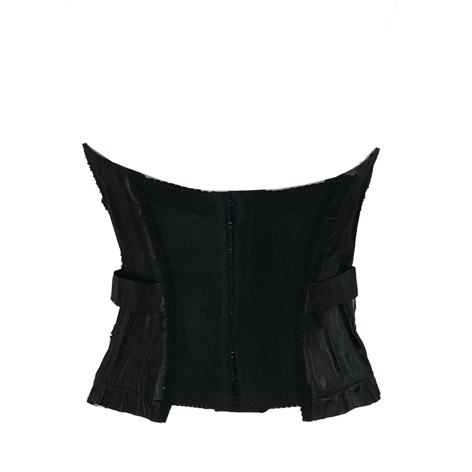 Delila bustier back Steampunk-inspired black bustier made from recycled cassette tape fabric with leather appliqués and raw edge detailing.