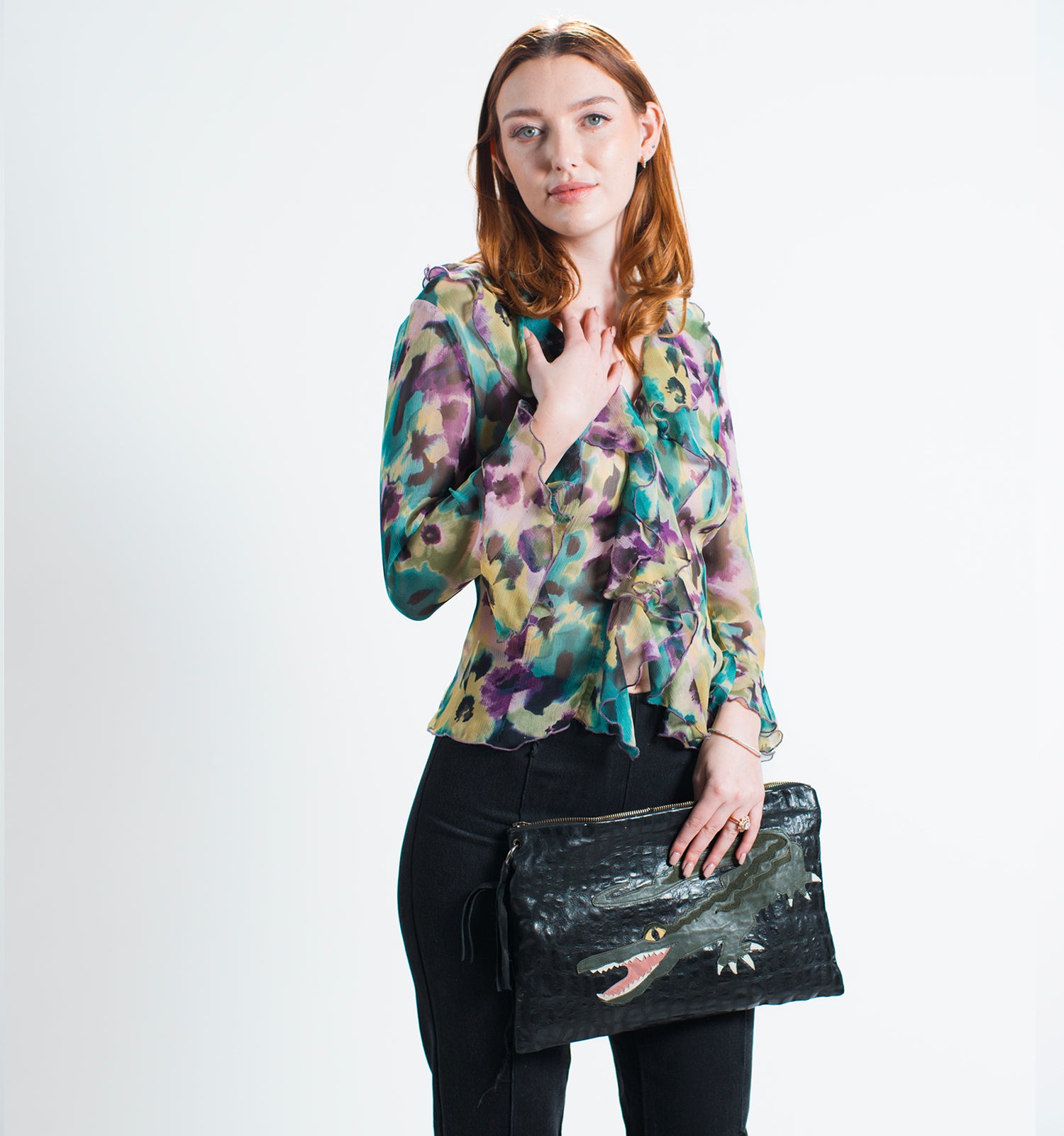 model with blouse and Upcycled black leather clutch bag with textured finish and appliquéd alligator