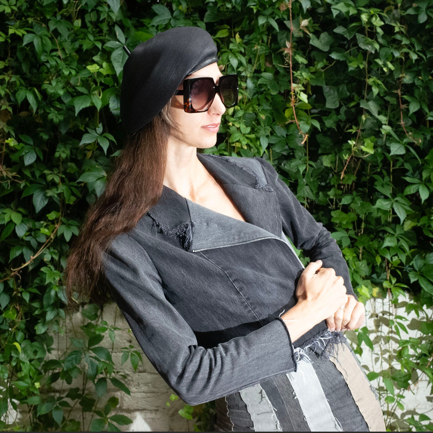 model in Angie Jacket in Distressed Black – upcycled black denim motorcycle jacket with raw edging and exposed zipper, one-of-a-kind wash and wear.