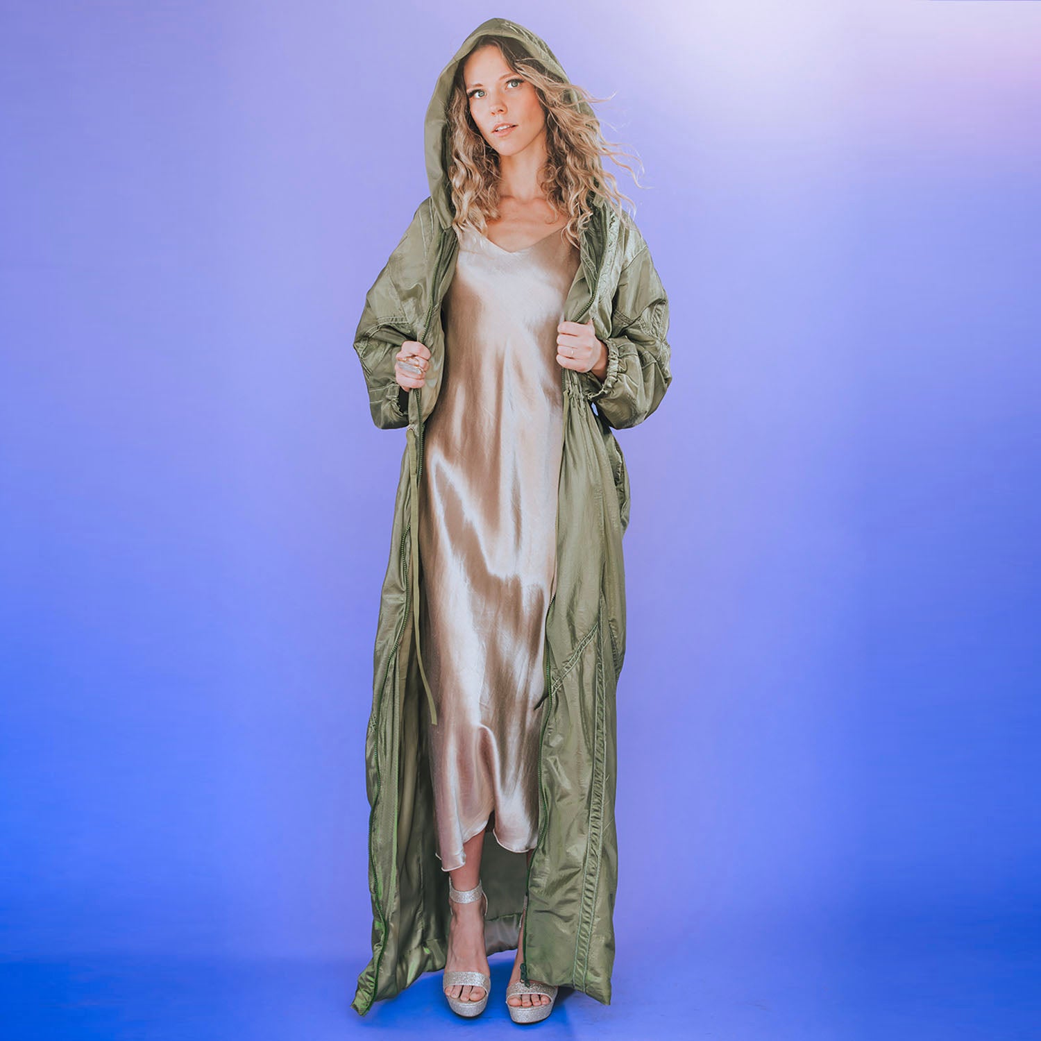 Olive green full-length bomber coat with hood, drawstring waist, and side pockets, made from upcycled parachute nylon.