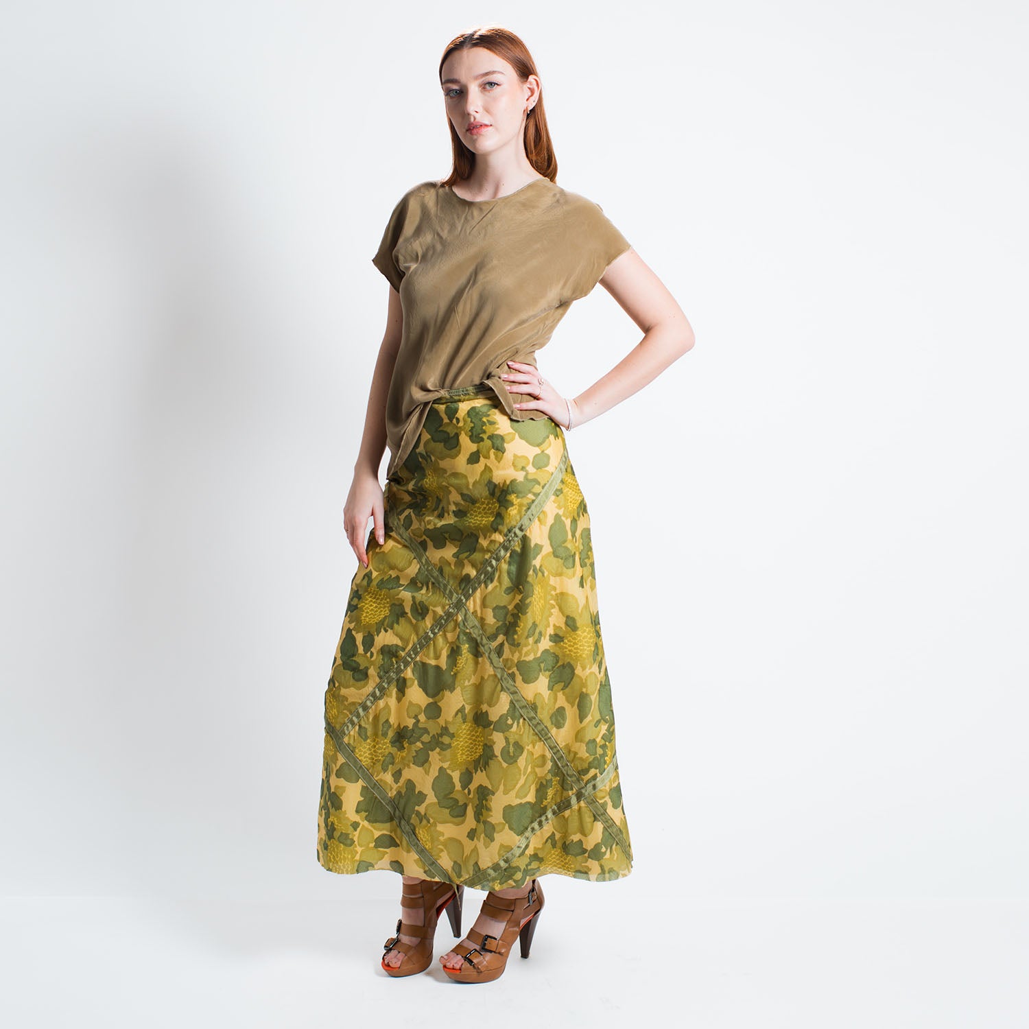model in Olive green camo print midi skirt made from upcycled parachute nylon with hidden sunflower details; bias-cut with subtle A-line shape.