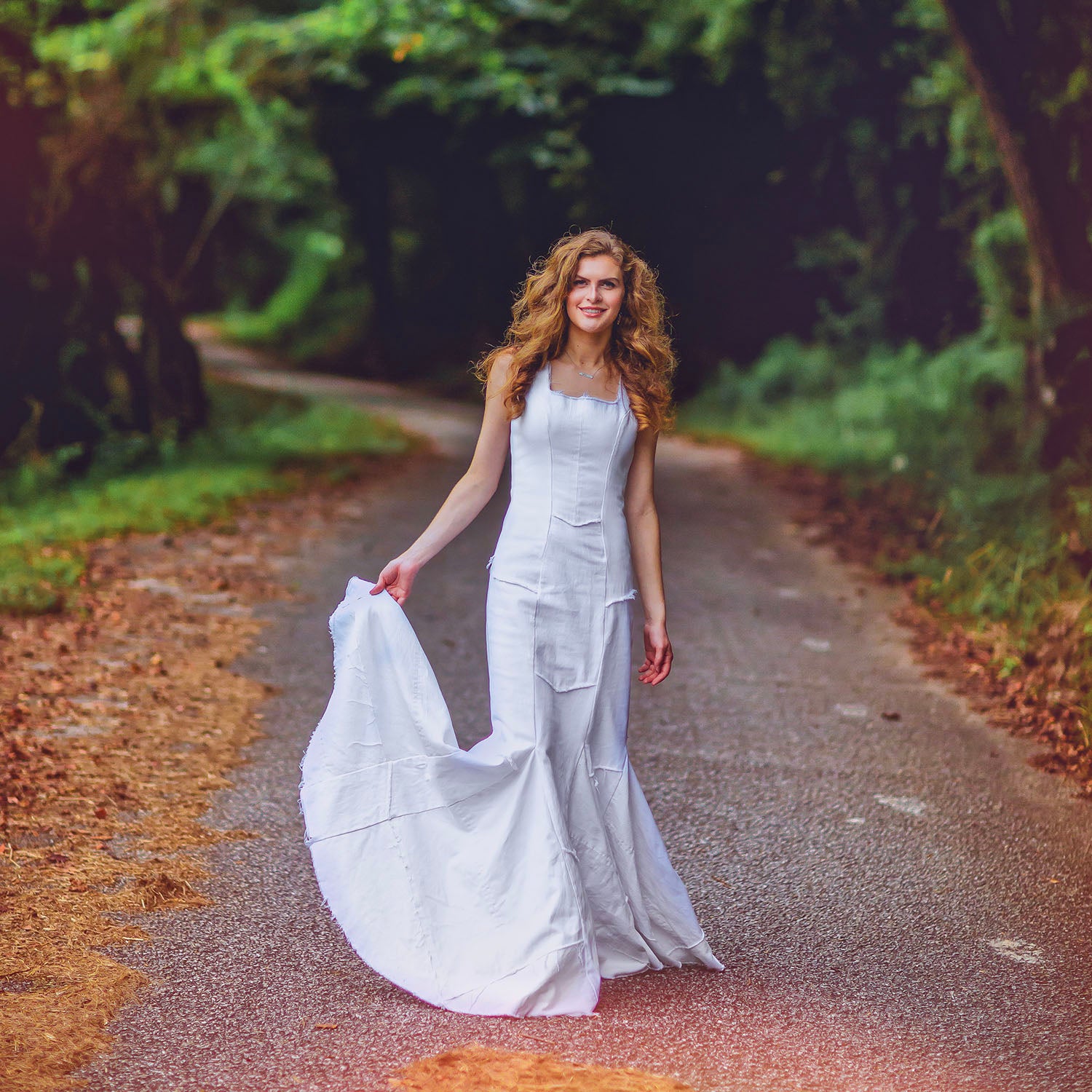 Model in Diana Dress in white – mermaid silhouette gown made from upcycled white denim, raw-edged with exposed back zipper, sculpted and formal.