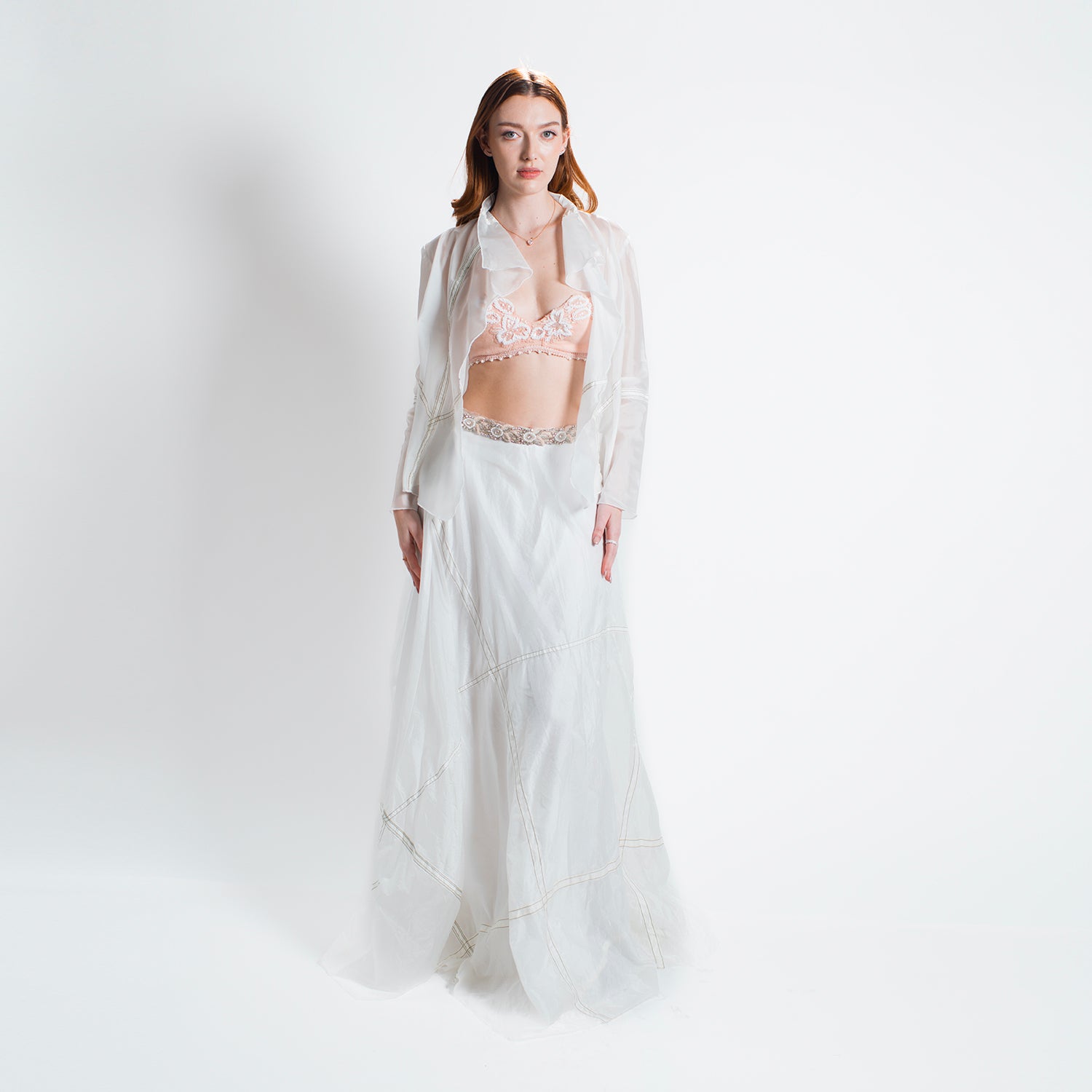 model Lightweight white parachute jacket with long sleeves and a softly draped, flutter-style front.