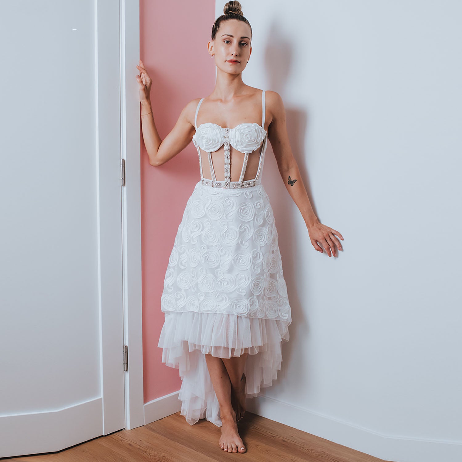 Model wearing high-low embroidered net skirt with ruffle hem.