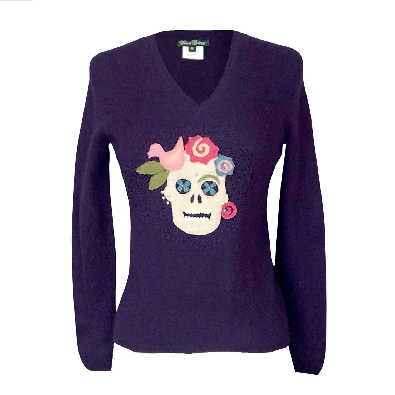 Deep plum cashmere sweater with colorful sugar skull appliqué, inspired by Frida Kahlo, embellished with flowers, birds, rhinestones, and studs.