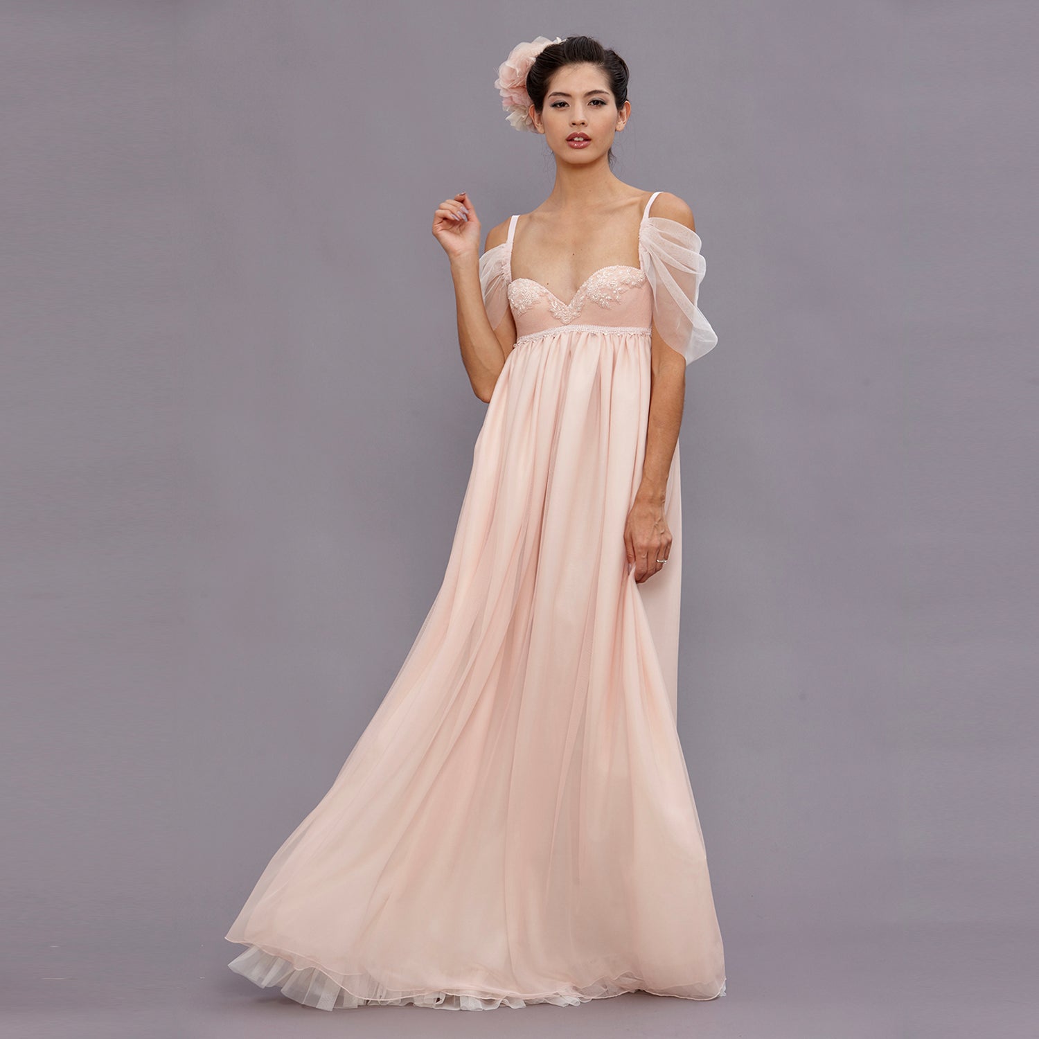 model Guinevere Blush Empire Gown with vintage beaded wool bodice, clear crystal bead details, and flowing English net skirt in soft blush, designed with an empire waist silhouette.