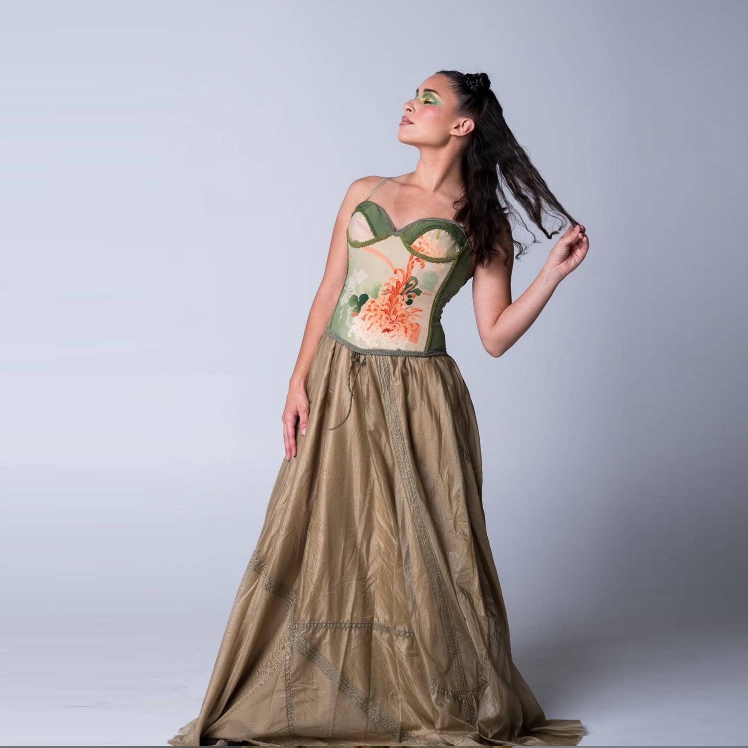 Model wearing a one-of-a-kind vintage kimono silk bustier with jade and coral floral motifs paired with a flowing bronze skirt.