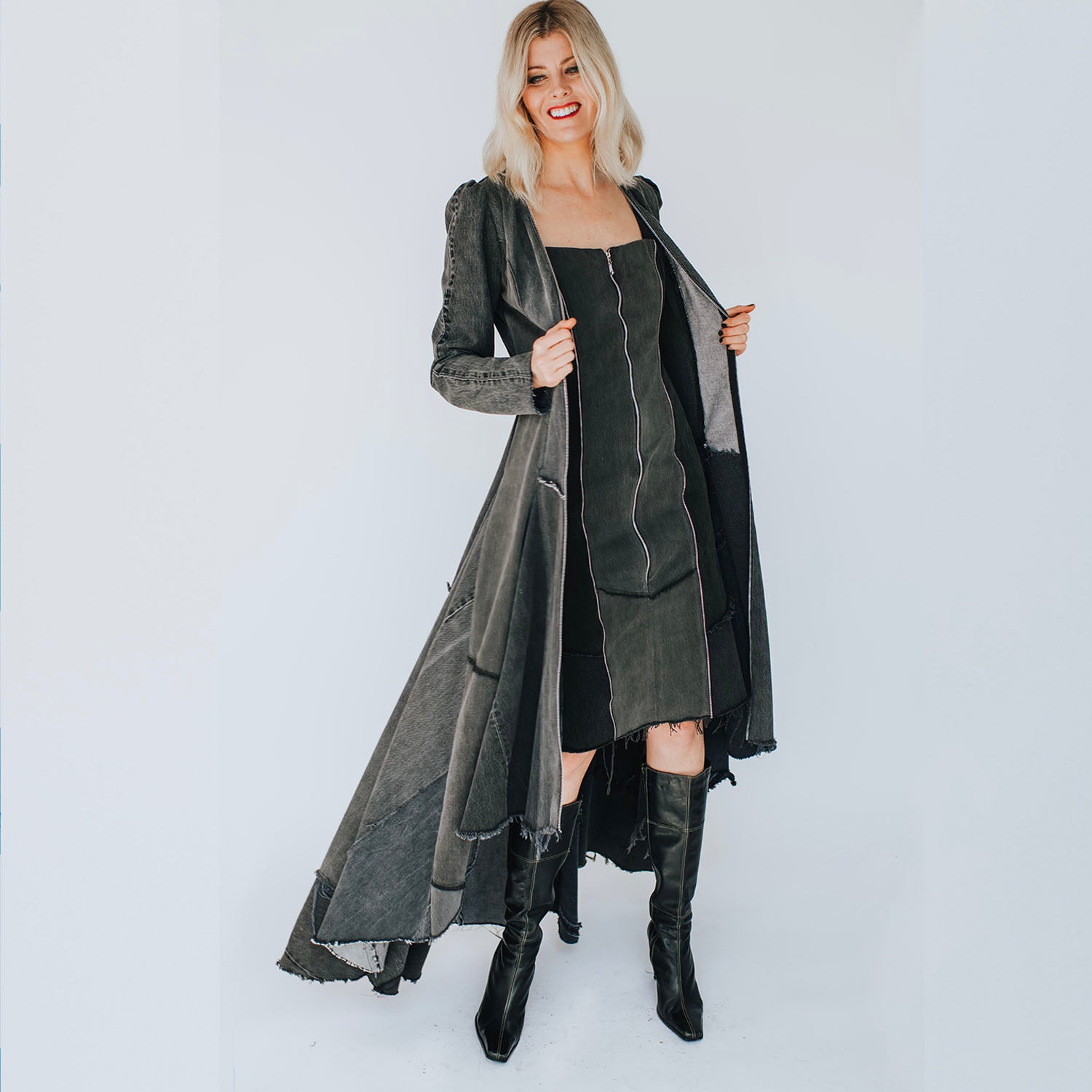 Distressed black fitted sheath dress made from upcycled denim with front zipper, raw edges, princess seam zippers, and studded hem.