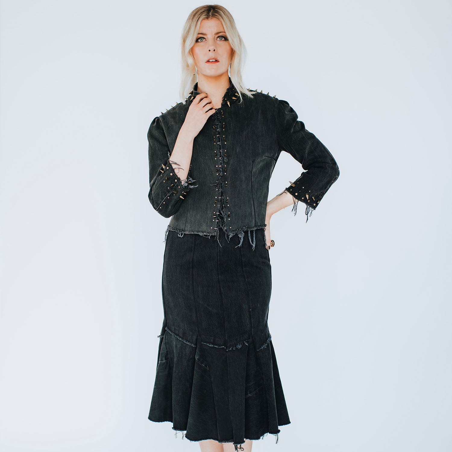 model in Suzi Jacket in distressed black denim with brass spikes and corset back, glam punk design by Deborah Lindquist 