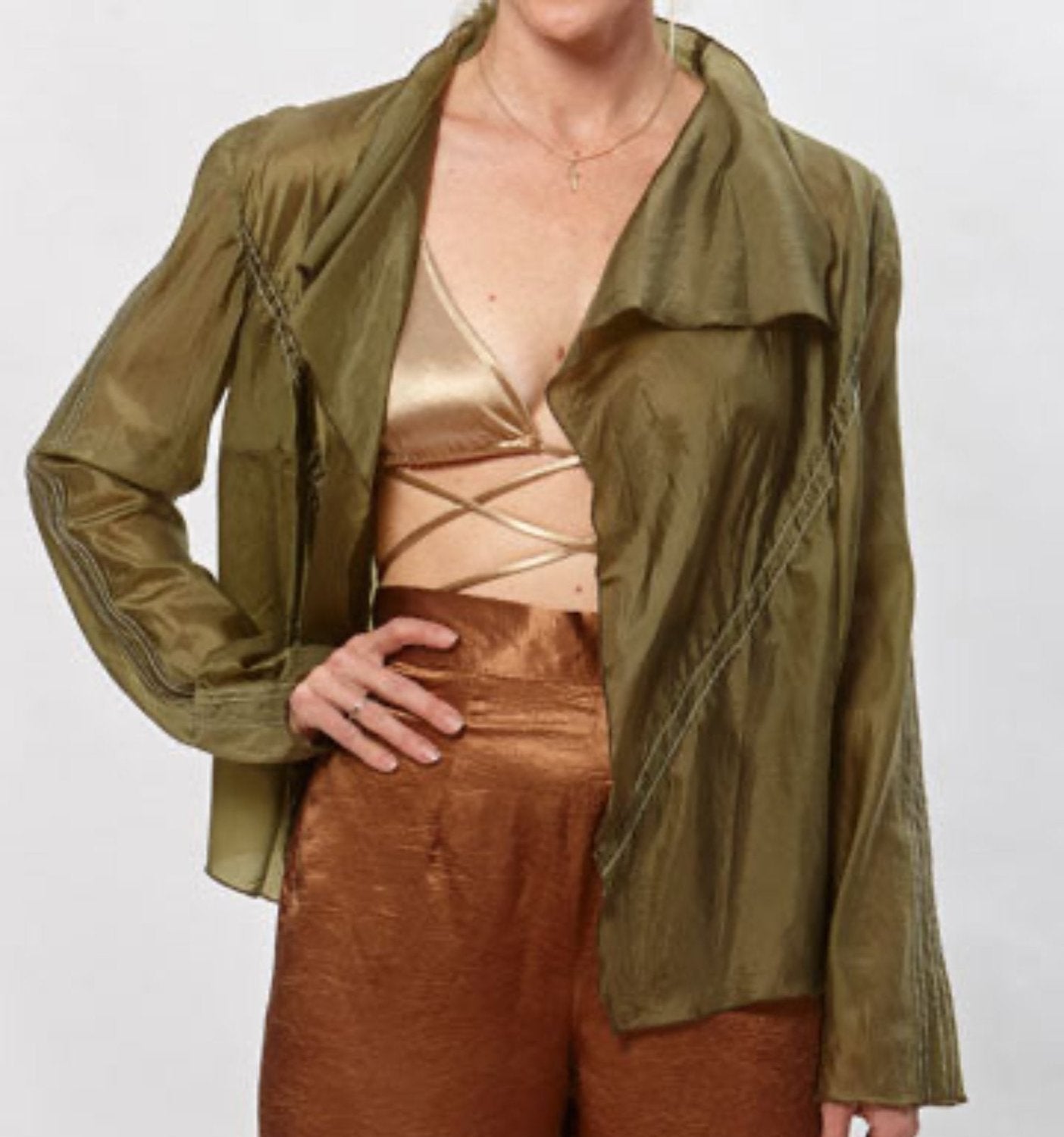 Lightweight olive green parachute jacket with long sleeves and a softly draped, flutter-style front.