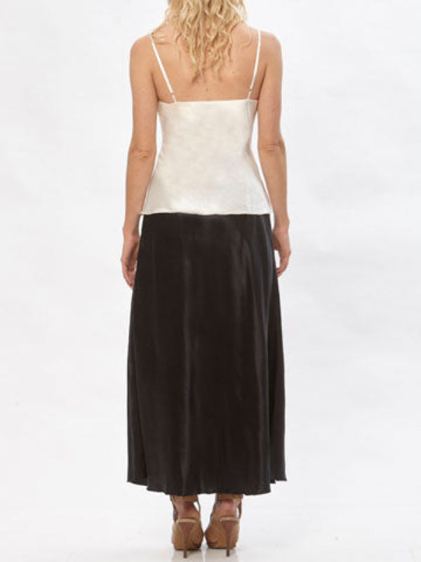 Model wearing the Katherine hemp/silk satin bias-cut skirt in black, paired with a cream camisole.