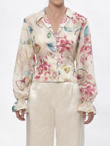 Silk floral blouse with tailored notched collar, puffed long sleeves, and ruffled elastic cuffs in soft pastel tones.