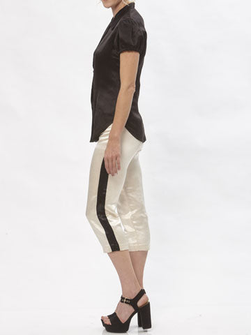 Model wearing cream hemp silk cigarette pants with black contrast side stripe and cropped hem, paired with black short-sleeve blouse.