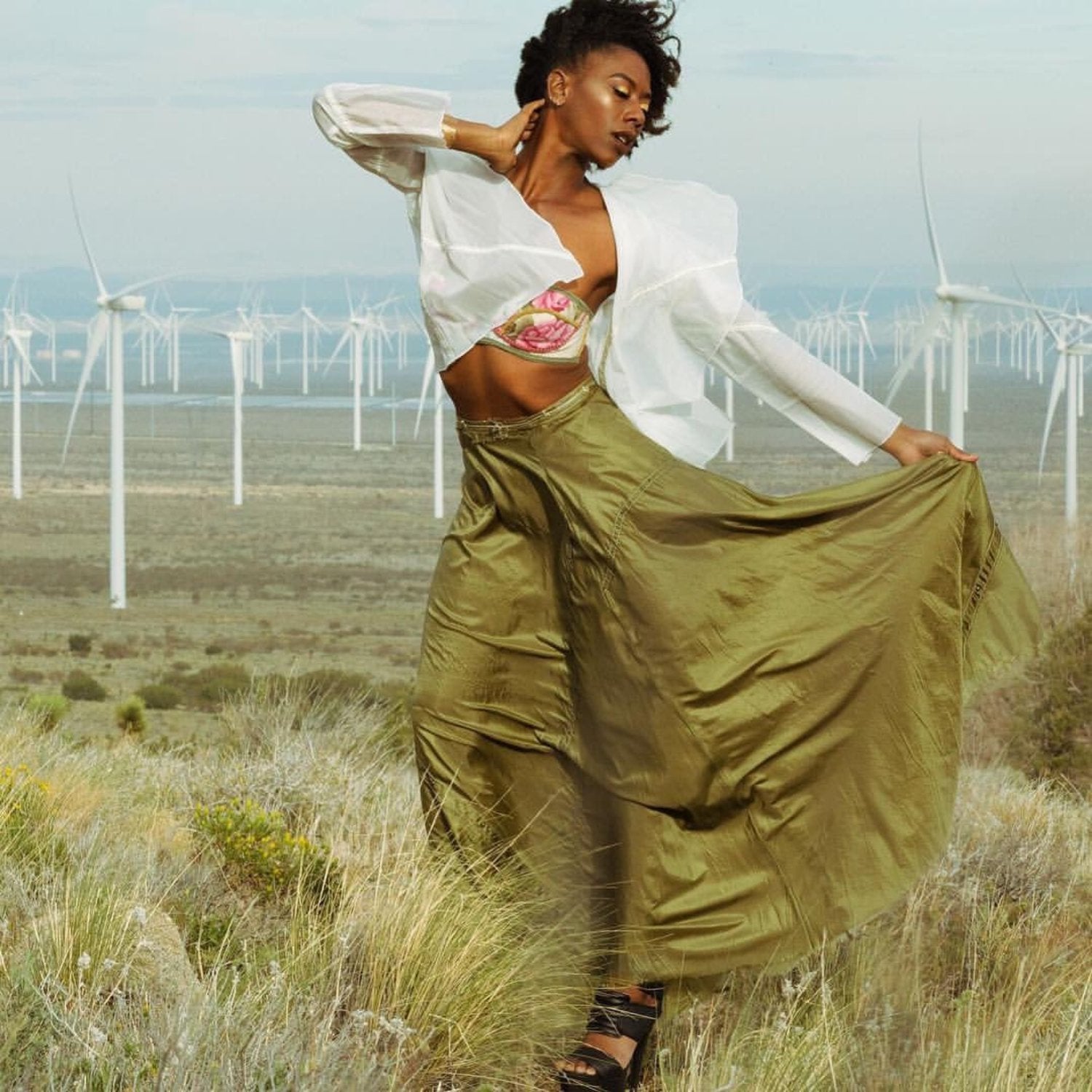 Dramatic olive green parachute skirt in a flowing half-circle silhouette with visible seamline details; made from upcycled military nylon.