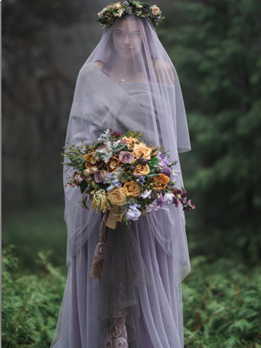 Model wearing the Ava Lavender Beaded Gown featuring a vintage beaded wool bodice, pale blue pearl accents, and a gathered English net skirt in a soft dusty mauve hue.