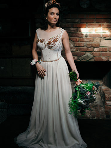model in Elysia Gown – one-of-a-kind vintage beaded wool bodice with illusion neckline and bronze floral beadwork, featuring a flowing English net and silk chiffon skirt in soft beige